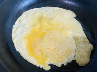 秋葵鸡蛋卷,锅中刷入少许油，倒入鸡蛋液，小火煎至成型