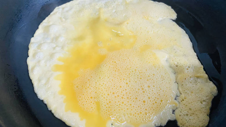 秋葵鸡蛋卷,锅中刷入少许油，倒入鸡蛋液，小火煎至成型