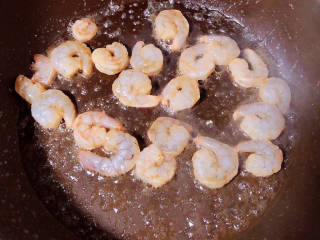玉米虾仁蛋炒饭,锅中倒入少许油，下入虾仁炒至变色。