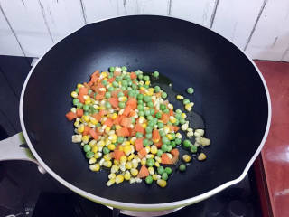 杂炒时蔬,倒入胡萝卜粒、豌豆、玉米粒翻炒片刻