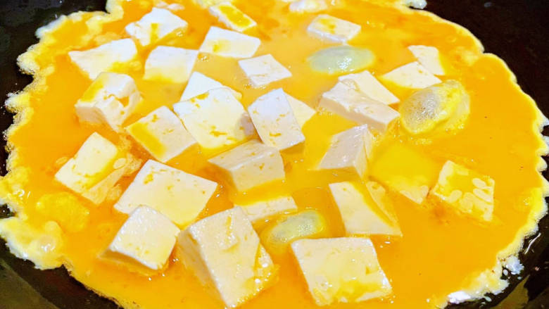 鸡蛋炖豆腐,锅中倒入底油加热淋入蛋液和豆腐