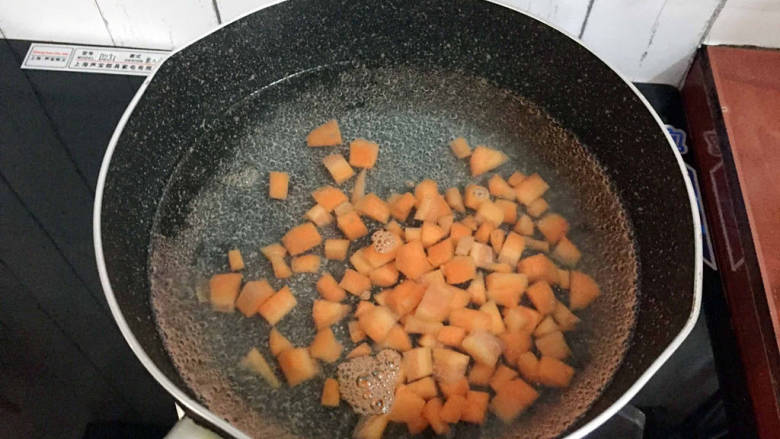 杂炒时蔬,锅中烧开水放入胡萝卜粒焯烫半分钟