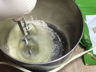 斓香斑马纹蛋糕,蛋清中加入柠檬汁，打发至起泡，分三次加入一半的白糖