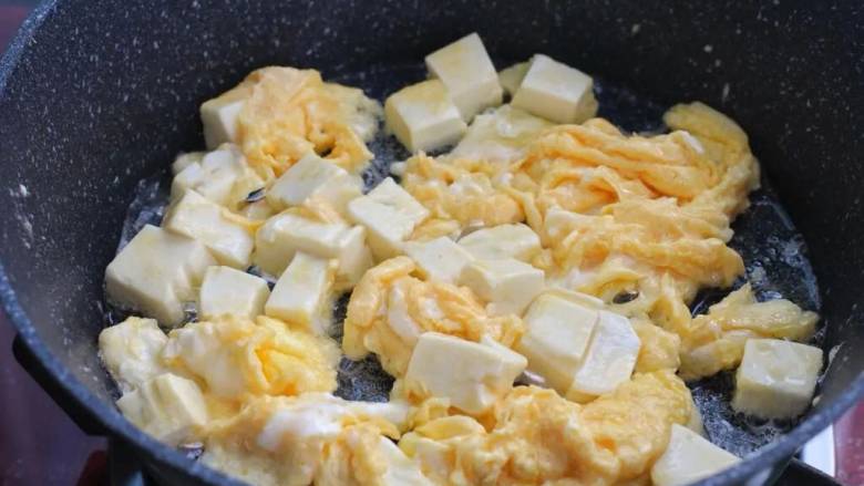鸡蛋炖豆腐,锅中倒入食用油烧热，将豆腐和蛋液一同倒进去，炒成小块盛出备用。