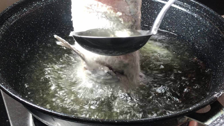 糖醋脆皮鱼,再用汤勺舀起热油浇在鱼身上的花刀鱼片上，以便定型