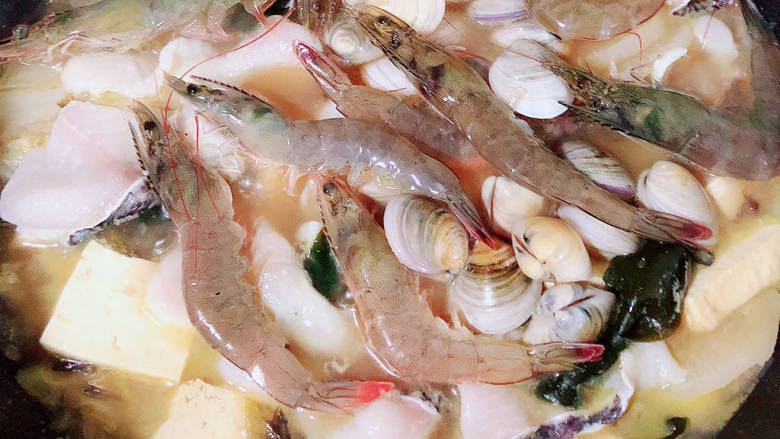 酸菜海鲜锅,再下入活虾和青蛤，盖盖儿煮六七分钟。