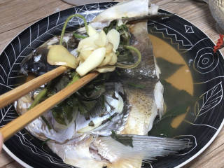 紫苏蒸鱼头,取出蒸好的鱼头，夹去鱼头上面的紫苏和葱姜蒜丢弃