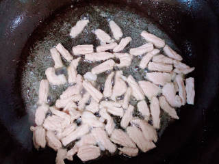 蒜苔香干,锅中倒入油，加热至五成热，放入肉丝翻炒均匀。