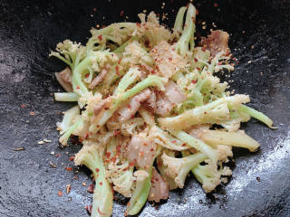 干锅菜花五花肉,加香蒜碎和少许干辣椒碎，翻炒均匀，大火炒至花菜有所变干